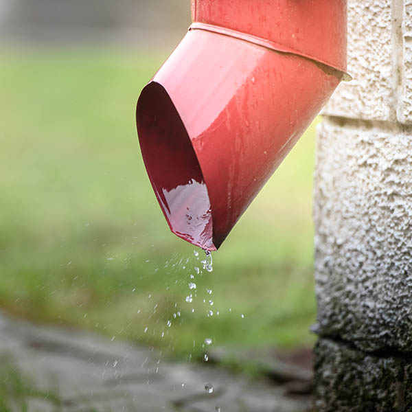 Rainwater flowing out of the red drain. Protection against flooding